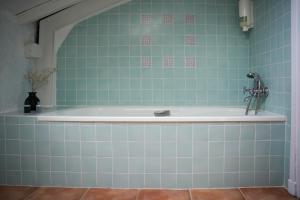 a bath tub in a bathroom with blue tiles at Planazo House in Arnuero +39 photos