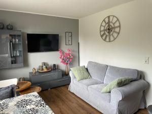 a living room with a couch and a tv at Haus Am Damm in Kleve
