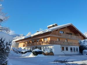 a chalet in the winter with snow on the ground at Hotel Seerose in Rottach-Egern