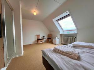 ein Schlafzimmer mit einem Bett und einem großen Fenster in der Unterkunft Sverres Hotel in Rønne