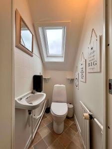 ein kleines Badezimmer mit Toilette und Waschbecken in der Unterkunft Sverres Hotel in Rønne + 18 Fotos