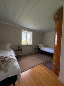 an attic room with two beds and a window at Tant Märtas rum & skafferi in Köinge