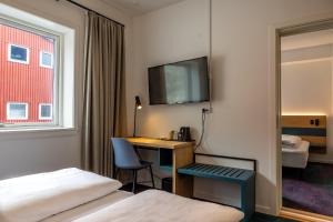 a hotel room with a desk and a bed at Hotel Aurora in Nuuk