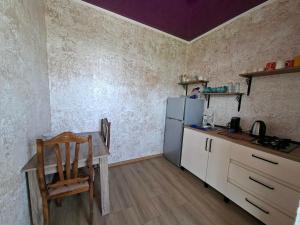 a kitchen with a table and a refrigerator at საოჯახო სასტუმრო დეა in Anaklia