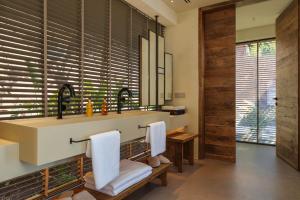 a bathroom with a sink and two white chairs at Klay Hotel Faralya Adults Only in Faralya
