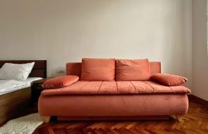 a couch sitting in a room with a bed at Fuchsl Palace Grand Suite - Ultra Central in Oradea