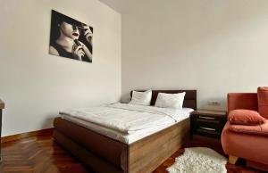 a bedroom with a bed with a picture on the wall at Fuchsl Palace Grand Suite - Ultra Central in Oradea +6 photos