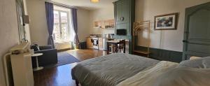 a bedroom with a bed and a kitchen at Le Chapitre Français 3 in Rochechouart