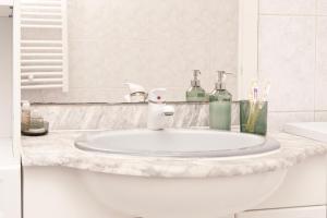 a bathroom with a white sink and a mirror at Appartement Cosy Case 6 pers parking proche Disney et Paris in Champs-sur-Marne +20 photos