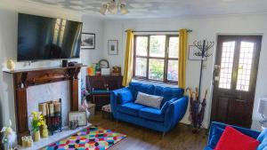 a living room with a blue chair and a fireplace at 'Mill Cottage' Parbold in Parbold
