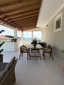 a living room with a table and chairs at Marea Blue Seaview Apartments of Santa Barbara in Marathias