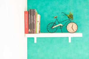a book shelf with a clock and books at Appartement Cosy Case 6 pers parking proche Disney et Paris in Champs-sur-Marne