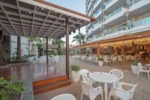 an outdoor patio with tables and chairs and a restaurant at Bull Escorial & Spa in Playa del Ingles