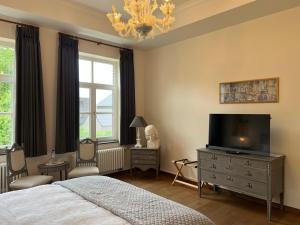 ein Schlafzimmer mit Bett und Flachbildfernseher in der Unterkunft De Pastory Peer in Grote-Brogel