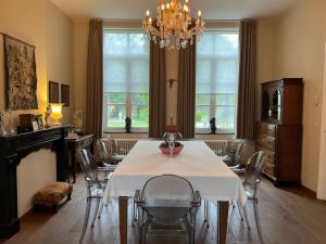 ein Esszimmer mit einem weißen Tisch und Stühlen in der Unterkunft De Pastory Peer in Grote-Brogel