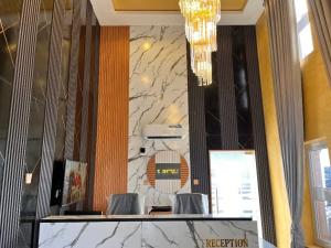 a lobby with two chairs and a wall with marble at Kelvin Cameo Resort Hotel in Madala