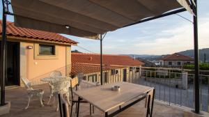 a patio with a table and chairs on a balcony at Casa da Moura - Arcos de Valdevez in Arcos de Valdevez