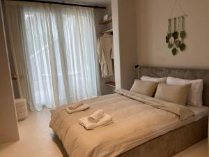 a bedroom with a large bed with two towels on it at Vaios Luxury Apartments in Polychrono