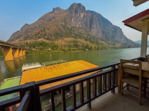 a boat on a river with a mountain in the background at Nongkhaiw Hostel in Nongkhiaw