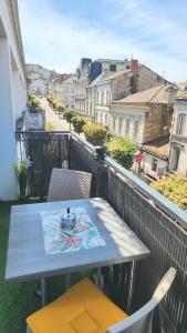 a table and chairs on a balcony with a view at La Bulle Gambetta in Angoulême