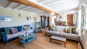 a living room with two couches and a table at Priors Mead Cottage in Claydon +17 photos