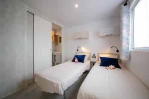 two beds in a small room with a window at Camping El Canto la Gallina in Valdemaqueda +30 photos