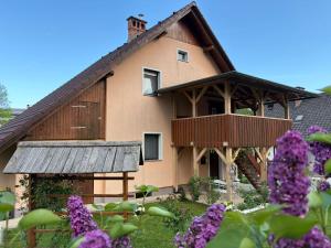 a house with a balcony and purple flowers at Apartment Ravnik in Bled