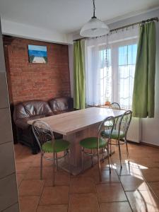 a dining room table with chairs and a couch at Dworek in Swarzewo