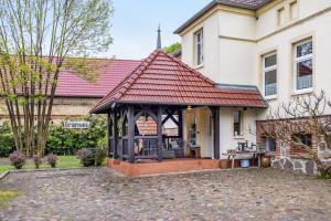 a gazebo in front of a house at Ferienhof Schönberg in Lindow