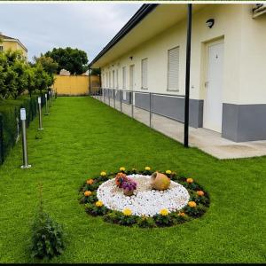 a garden with a flower arrangement in a circle in the grass at L'imbarco ROOMS in Badolato Stazione