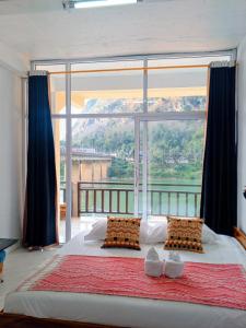 a bedroom with a large bed with a large window at Nongkhaiw Hostel in Nongkhiaw