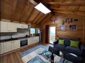 a kitchen and living room in a log cabin at Baita dell'Est in Mese