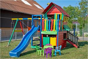 a colorful playground with a slide and chairs at Pferdefreunde Loberhof in Weihenzell