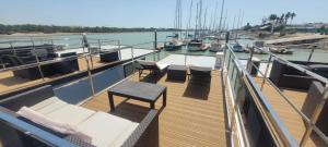 a deck of a boat with a table and chairs at SEA & SOUL SUITe in El Puerto de Santa María