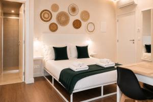 a bedroom with a bed with two towels at Social Lodge Cabouqueira Studios in Funchal
