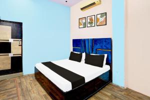 a bedroom with a bed with a blue wall at HOTEL O SUNSHINE in Ghaziabad