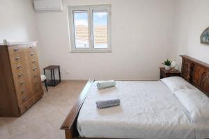 a bedroom with a bed and a dresser and a window at WHITE COAST APARTMENTS - Family Stays and Free Parking in Realmonte