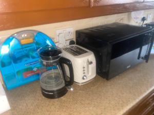 a kitchen counter with a coffee maker and a toaster at A Spacious Odyssey in Dagenham
