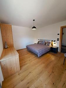 a bedroom with a bed and a wooden floor at Casa Bassanello in Candide