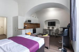 a bedroom with a bed and a kitchen with a table at Old Town Square Residence by Emblem in Prague