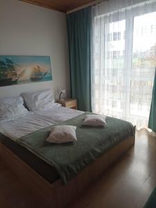 a bedroom with a bed with pillows and a window at Willa Perełka in Mielno
