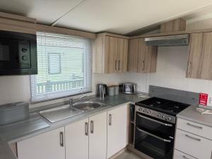 a kitchen with a sink and a stove top oven at Beach View Eden Heights Kinkell Braes 2 bedrooms 2 bathrooms in St. Andrews