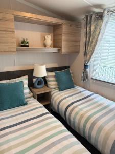 two beds sitting in a room with a window at Beach View Eden Heights Kinkell Braes 2 bedrooms 2 bathrooms in St. Andrews