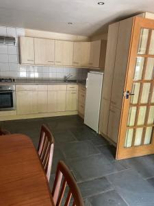a kitchen with a table and a white refrigerator at La Bruyere in Saint-Pois