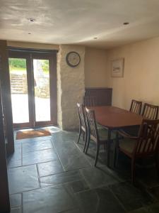 a dining room with a table and chairs and a clock at La Bruyere in Saint-Pois +9 photos