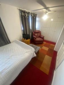 a bedroom with a bed and a chair at A Spacious Odyssey in Dagenham