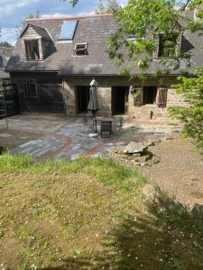 an outdoor patio with a house with a roof at La Bruyere in Saint-Pois