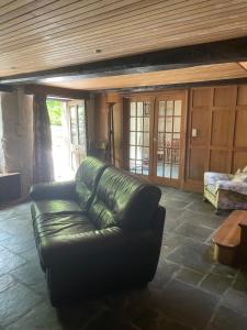 a living room with a leather couch and a table at La Bruyere in Saint-Pois