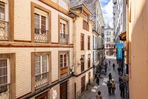 a group of people walking down a street with buildings at Hostal Oria in Luarca +42 photos