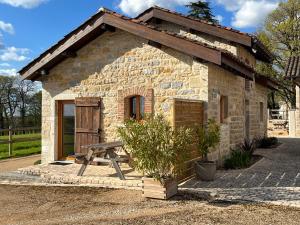 a stone building with a picnic table in front of it at La ferme des Soudanières in Ceyzériat